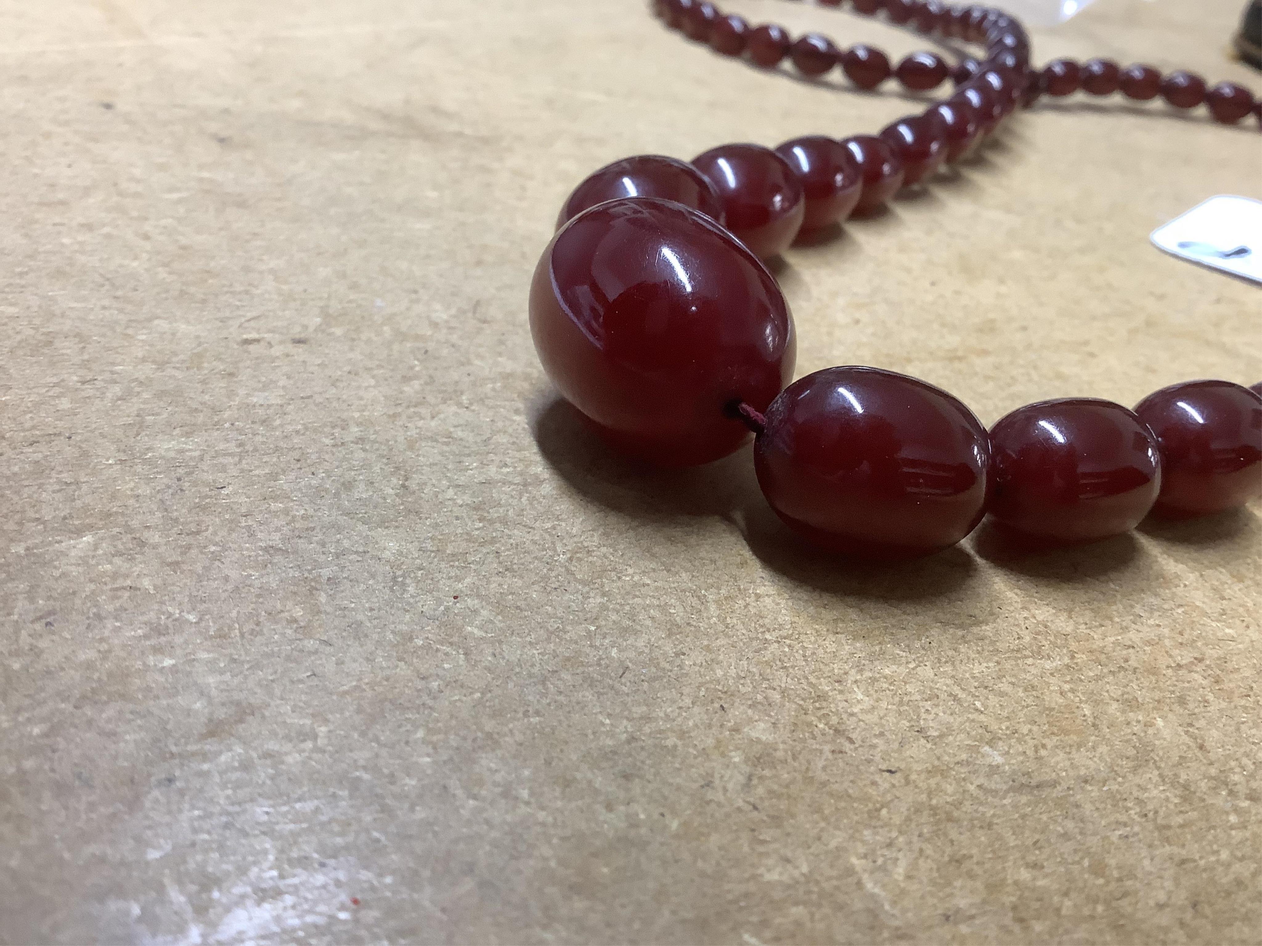 A single strand graduated simulated cherry amber bead necklace, 68cm, gross weight 44 grams. Condition - fair to good